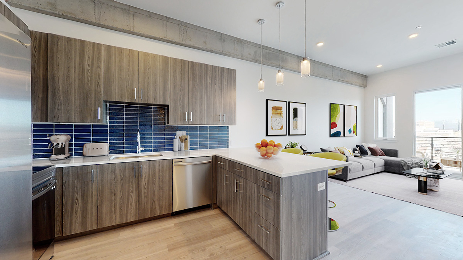 A photo of a kitchen and living room at POP Denver, luxury apartments in Santa Fe Art District.